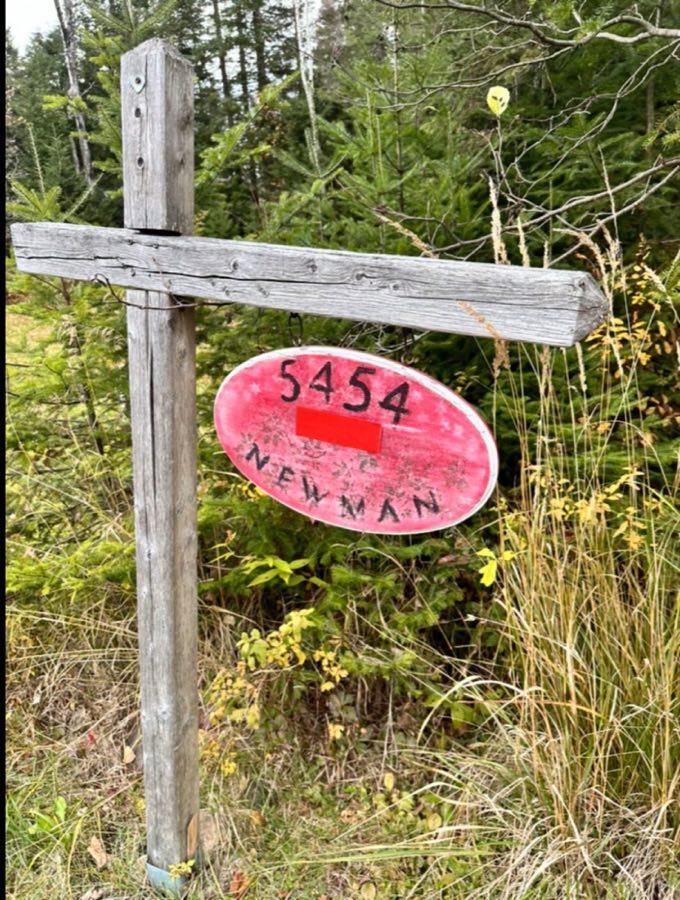 The red Newman welcome sign at 5454 Chemin Martin
